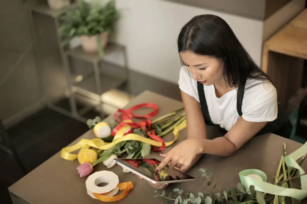 A florist checking an order on a tablet